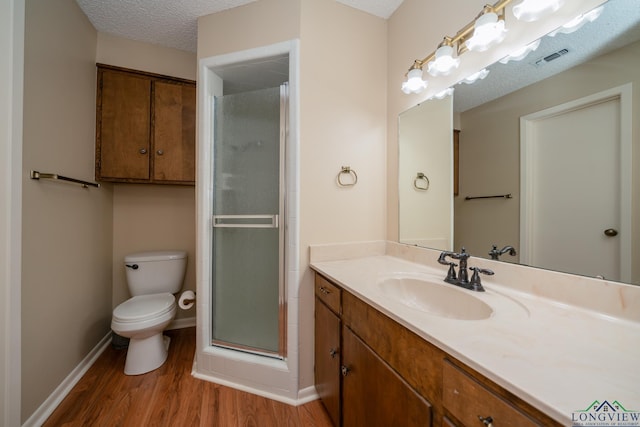 1002 Ruby St, Gilmer, TX 75644 - full bath featuring a stall shower, toilet, baseboards, wood finished floors, and vanity