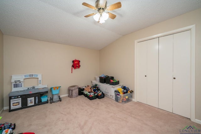 1002 Ruby St, Gilmer, TX 75644 - playroom with vaulted ceiling, baseboards, a textured ceiling, carpet flooring, and ceiling fan
