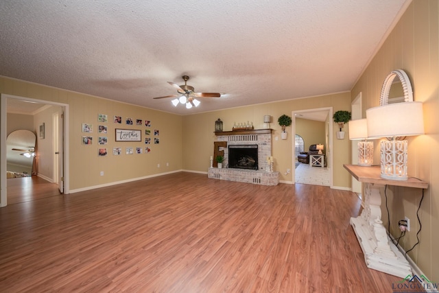 1002 Ruby St, Gilmer, TX 75644 - unfurnished living room featuring a ceiling fan, a textured ceiling, ornamental molding, and light wood-style flooring