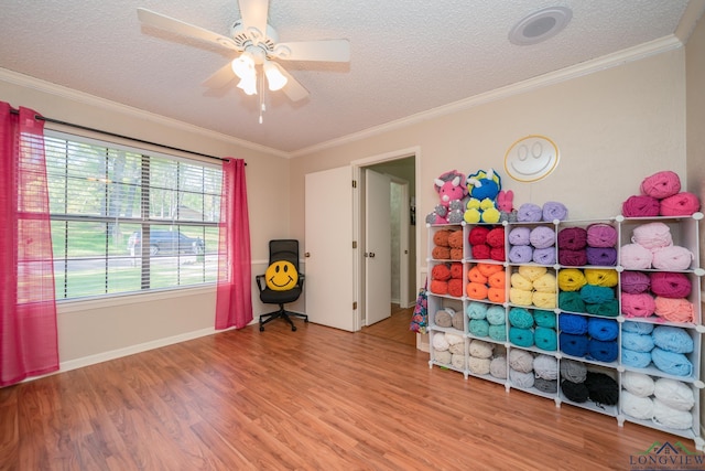 1002 Ruby St, Gilmer, TX 75644 - playroom featuring a textured ceiling, baseboards, wood finished floors, ceiling fan, and ornamental molding