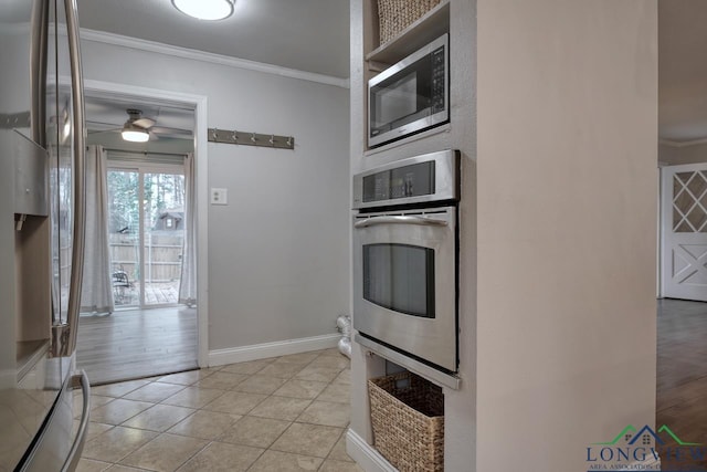 kitchen with ornamental molding, appliances with stainless steel finishes, light tile patterned flooring, and ceiling fan