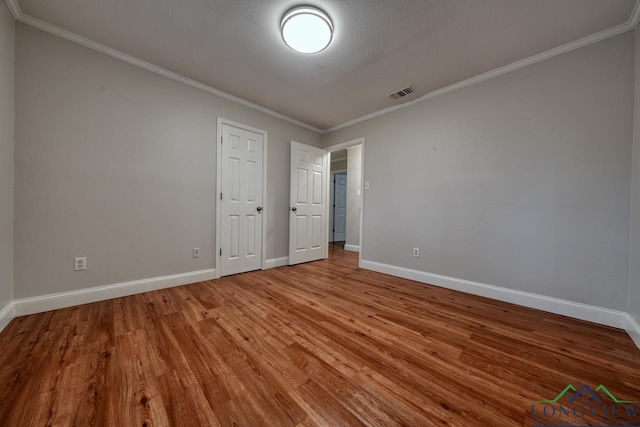 unfurnished room with hardwood / wood-style flooring and ornamental molding