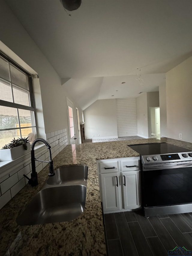 kitchen with sink, backsplash, electric range, light stone countertops, and white cabinets