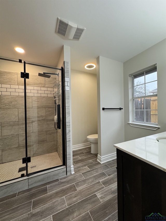 bathroom featuring vanity, toilet, and an enclosed shower