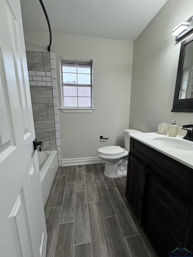 full bathroom featuring vanity, tiled shower / bath, and toilet