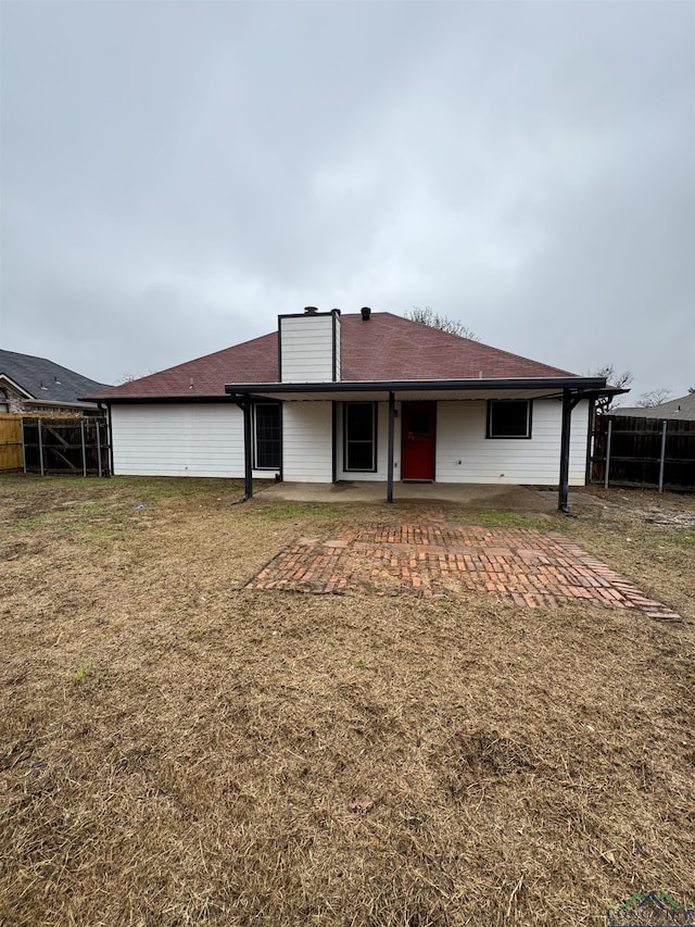 rear view of house featuring a yard and a patio area