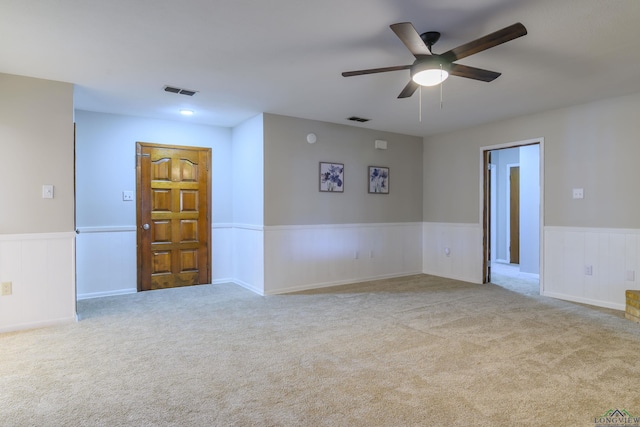 spare room with carpet, wainscoting, and visible vents