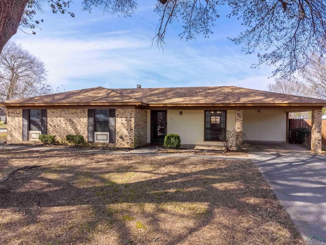 ranch-style home featuring driveway and brick siding