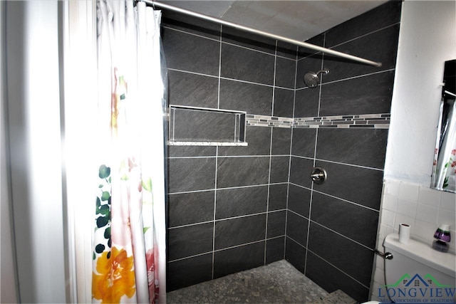 bathroom with toilet and tiled shower