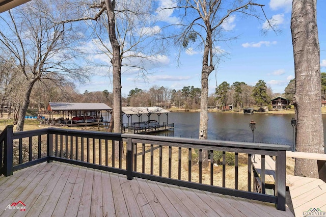 wooden deck with a dock and a water view