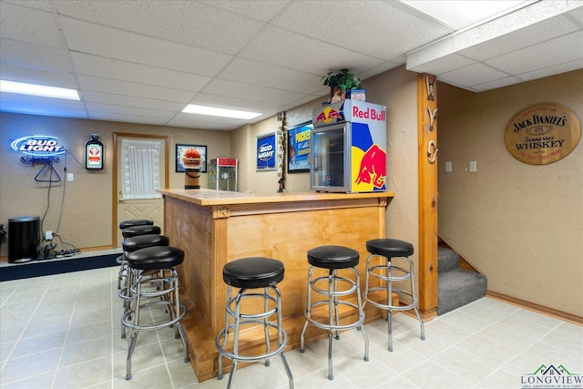 1483 County Road 1596, Avinger, TX 75630 - indoor dry bar featuring a paneled ceiling, baseboards, stairs, and light tile patterned floors