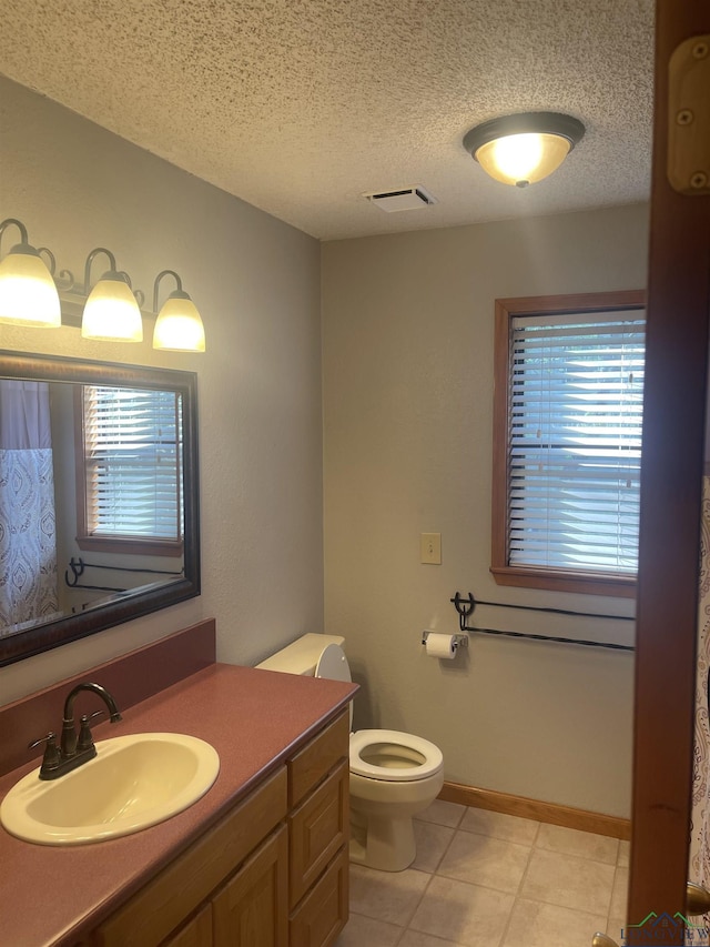 1483 County Road 1596, Avinger, TX 75630 - bathroom with toilet, vanity, a textured ceiling, tile patterned floors, and healthy amount of natural light