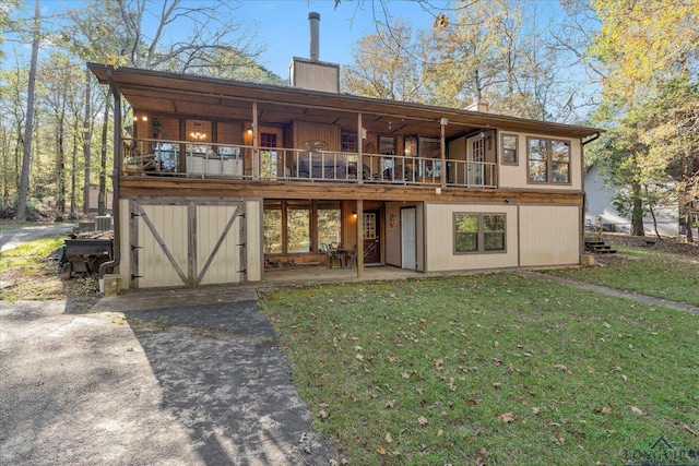 1483 County Road 1596, Avinger, TX 75630 - back of property with a chimney, a lawn, a patio area, and a wooden deck