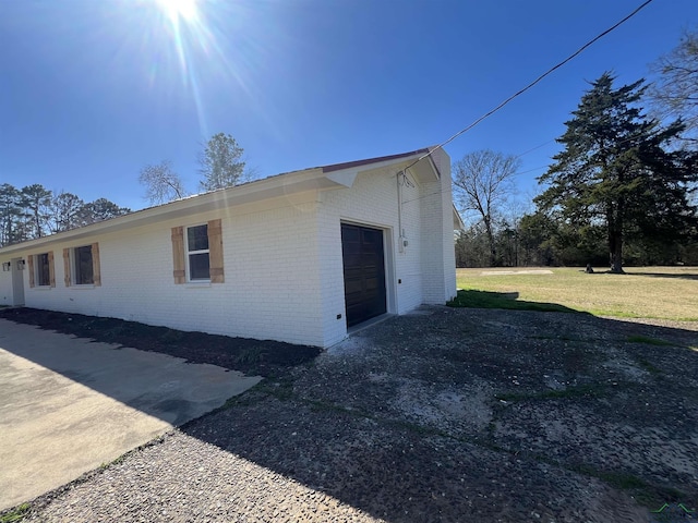 view of side of home featuring a garage and a yard