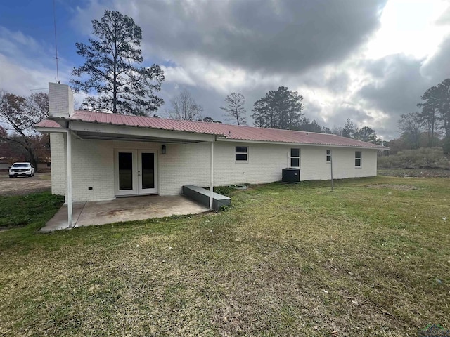 back of house featuring a lawn, a patio area, and central AC