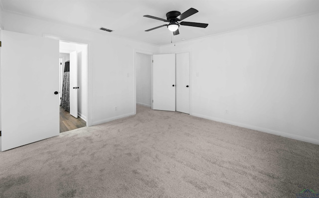 unfurnished room with carpet flooring, ceiling fan, and ornamental molding