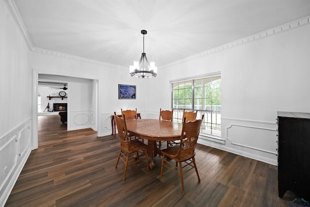 dining space featuring ornamental molding, dark wood-type flooring, and a chandelier