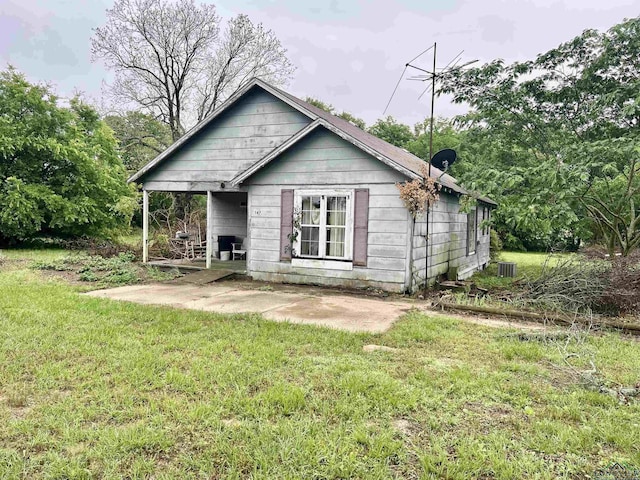 rear view of house featuring a patio, central AC unit, and a lawn