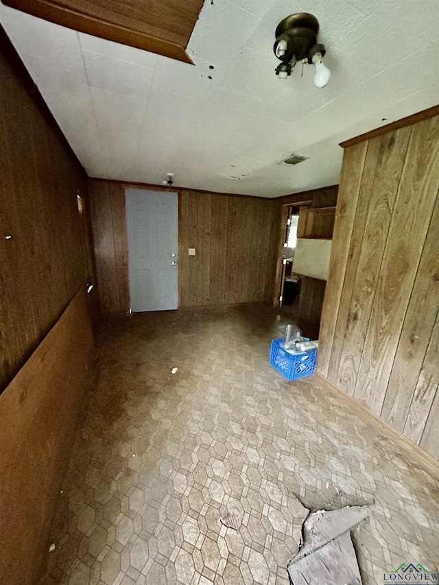 unfurnished living room with wooden walls