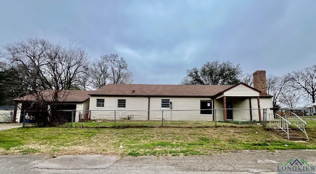 single story home with a chimney and fence