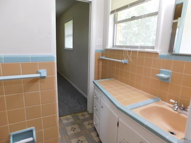 200 Hickory St, Gladewater, TX 75647 - bathroom featuring vanity, tile walls, and wainscoting