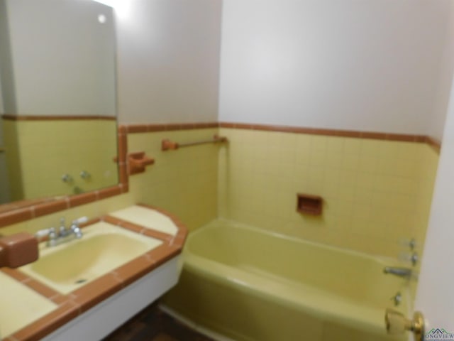 200 Hickory St, Gladewater, TX 75647 - full bathroom featuring a garden tub, vanity, a wainscoted wall, and tile walls