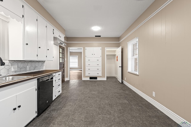 kitchen with white cabinets, decorative backsplash, sink, and black dishwasher