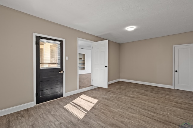 foyer entrance with dark wood-type flooring and a textured ceiling