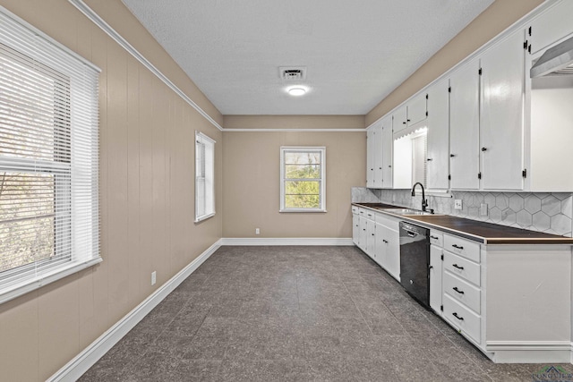 kitchen with white cabinetry, black dishwasher, wall chimney range hood, sink, and backsplash