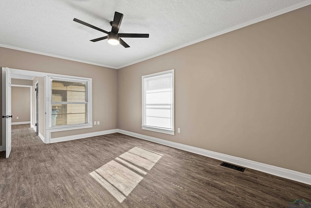 empty room with ceiling fan, wood-type flooring, ornamental molding, and a textured ceiling