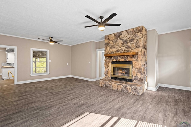 unfurnished living room featuring ceiling fan, dark hardwood / wood-style flooring, a fireplace, a textured ceiling, and ornamental molding