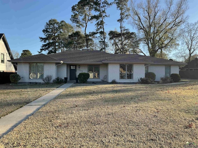 ranch-style home featuring a front yard and brick siding