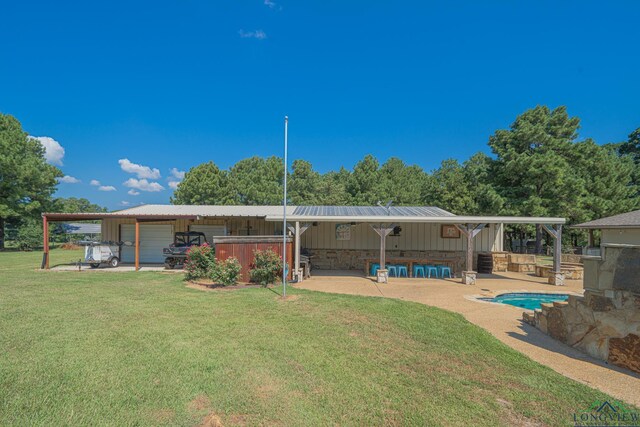 322 Roy Green Rd, Longview, TX 75602 - rear view of house featuring a lawn, board and batten siding, a metal roof, a detached garage, and a patio area