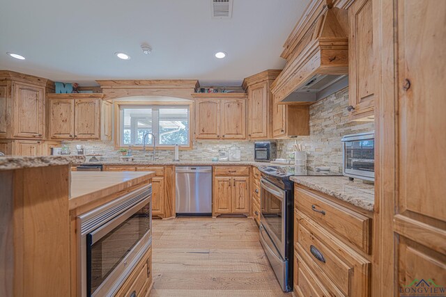 322 Roy Green Rd, Longview, TX 75602 - kitchen with stainless steel appliances, custom exhaust hood, light wood finished floors, light stone countertops, and recessed lighting