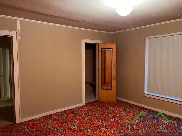 unfurnished room with a textured ceiling and crown molding