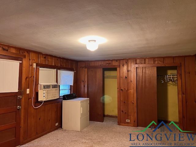 clothes washing area featuring cooling unit, washer / dryer, and light carpet