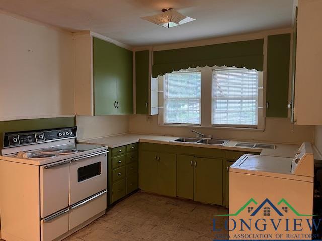 kitchen featuring green cabinets, white range, sink, and washing machine and dryer