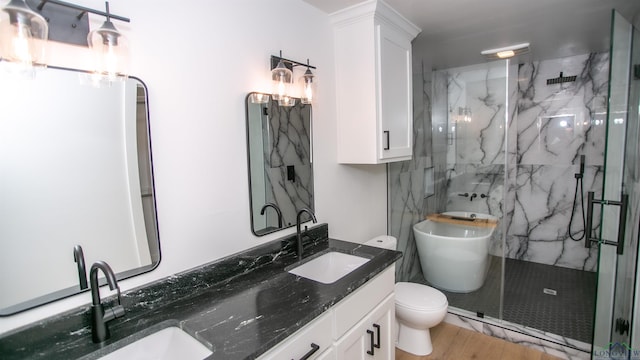 bathroom featuring vanity, hardwood / wood-style flooring, toilet, and a shower with shower door