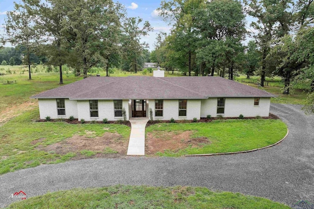 single story home with a front lawn, brick siding, and roof with shingles