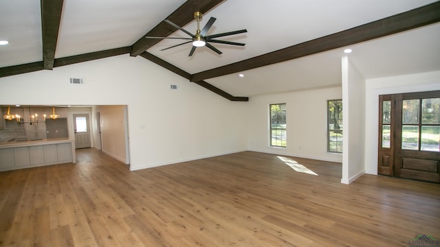 unfurnished living room featuring vaulted ceiling with beams, ceiling fan, and light wood-type flooring