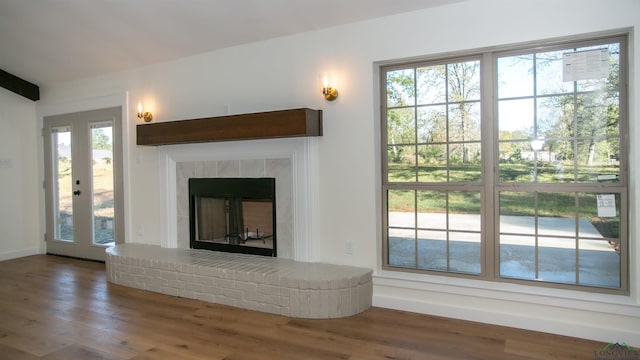 unfurnished living room featuring dark hardwood / wood-style flooring, a fireplace, and lofted ceiling