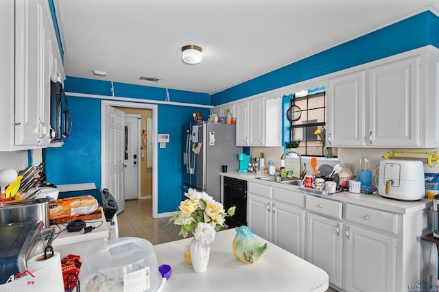 kitchen featuring sink, black appliances, white cabinetry, and a textured ceiling