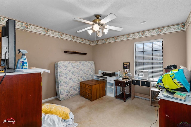 carpeted office space featuring a textured ceiling and ceiling fan