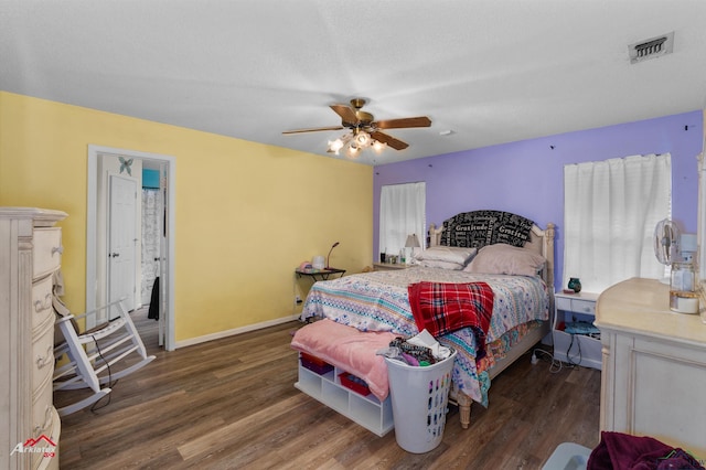 bedroom featuring ceiling fan, dark wood-type flooring, and multiple windows