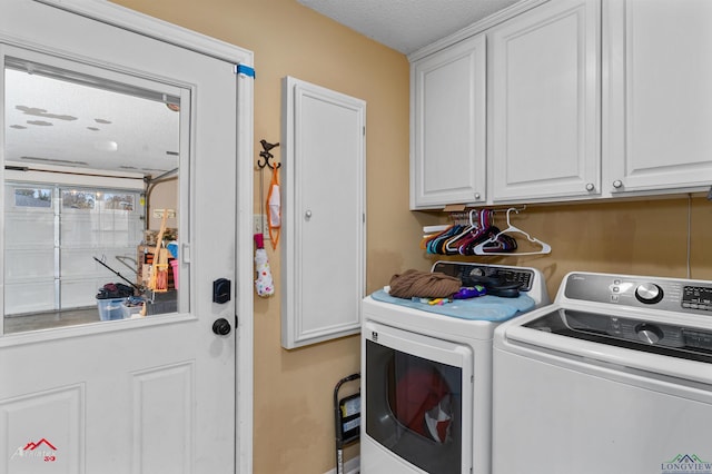 clothes washing area featuring cabinets, a textured ceiling, and washer and clothes dryer