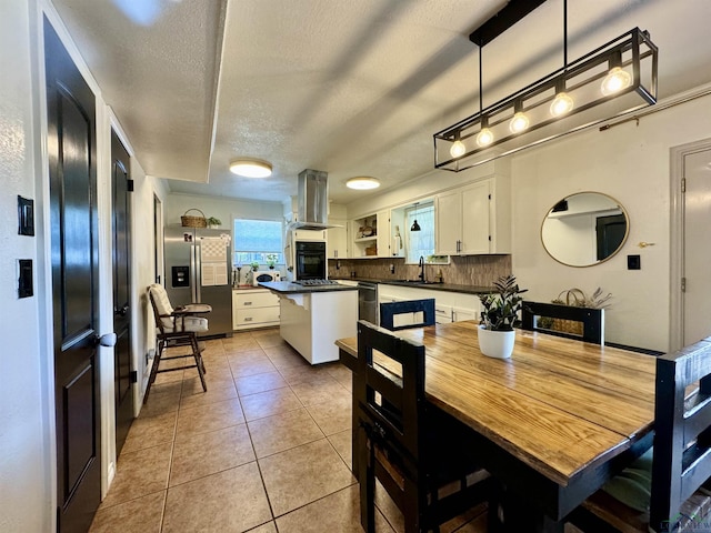 tiled dining space with sink and a textured ceiling