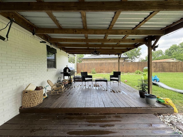 wooden terrace featuring area for grilling and a lawn