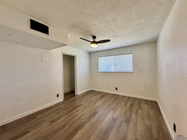 unfurnished room with hardwood / wood-style flooring, ceiling fan, and a textured ceiling