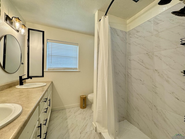 bathroom featuring walk in shower, vanity, toilet, and a textured ceiling