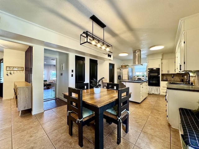 tiled dining area featuring sink and a textured ceiling